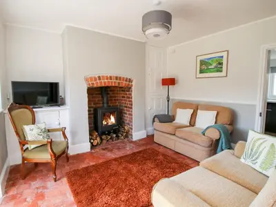 a living room with a fireplace and a couch and chairs at The Ferns in Ludlow