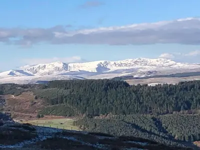 an aerial view of snow covered mountains with trees at 3-Bed Cottage Near Lake Vyrnwy Garden & PetsOk in Hirnant