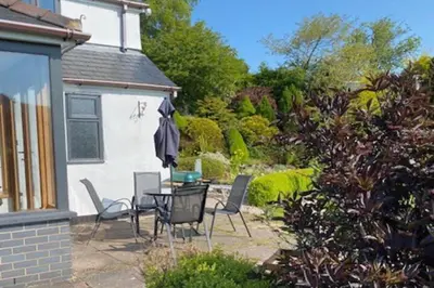 a patio with a table and chairs in a yard at 3-Bed Cottage Near Lake Vyrnwy Garden & PetsOk in Hirnant