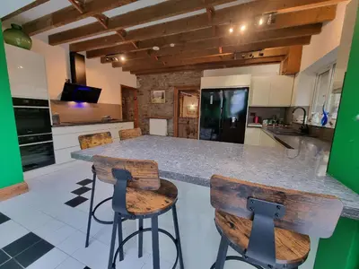 a kitchen with a counter and two stools at Cringoed House in Aberaeron