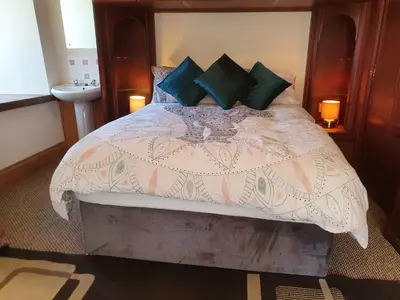 a bedroom with a large bed with a white comforter at Cringoed House in Aberaeron