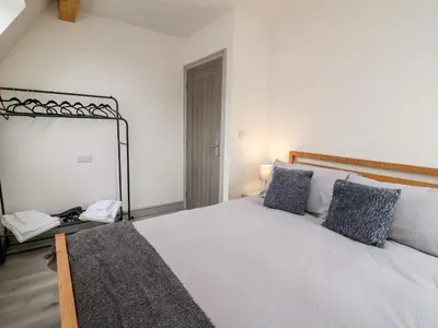 a bedroom with a large white bed with blue pillows at Brecknock Cheviot - The Sheepfold in Llandrindod Wells
