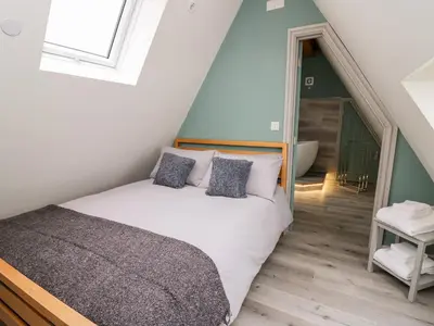 a bedroom with a bed and a staircase at Brecknock Cheviot - The Sheepfold in Llandrindod Wells