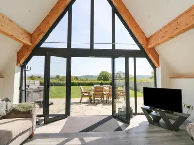 an open living room with a large window and a patio at Brecknock Cheviot - The Sheepfold in Llandrindod Wells