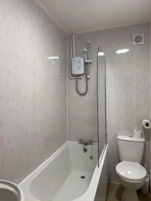 a bathroom with a tub and a toilet and a shower at Robert's Cottage in Abergynolwyn