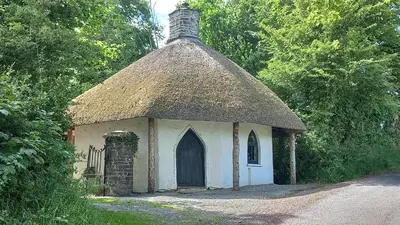 a small cottage with a thatch roof and a door at Gelly Dylan Thomas Paradise in Lampeter