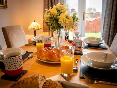 a wooden table with breakfast foods and orange juice at Town Location for Shrewsbury with 3 Bedrooms - Pass the Keys in Shrewsbury