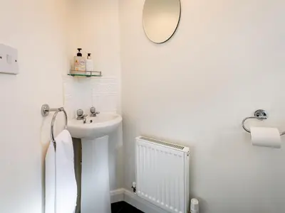 a white bathroom with a sink and a mirror at Town Location for Shrewsbury with 3 Bedrooms - Pass the Keys in Shrewsbury