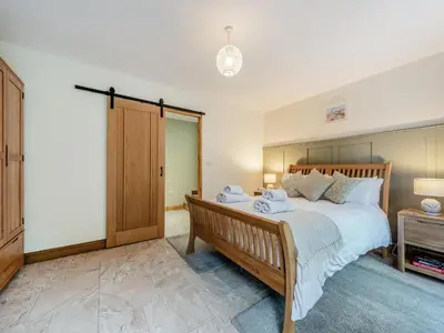 a bedroom with a large bed and a wooden closet at Bwlchygwynt in Rhandirmwyn