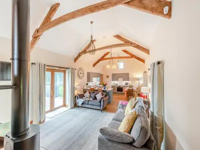 a living room with a fireplace and an open floor plan at Bwlchygwynt in Rhandirmwyn