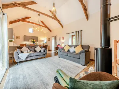 a living room with two couches and a kitchen at Bwlchygwynt in Rhandirmwyn