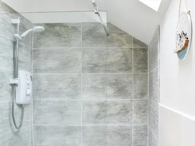 a shower stall in a bathroom with a tile floor at The Barn in Llangwm