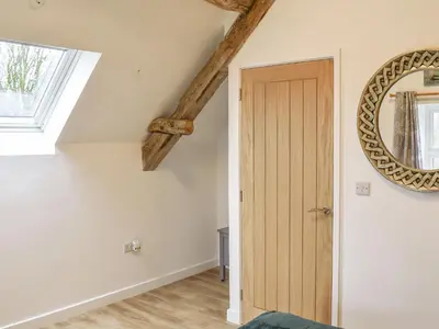 a room with a wooden door and a mirror at The Barn in Llangwm