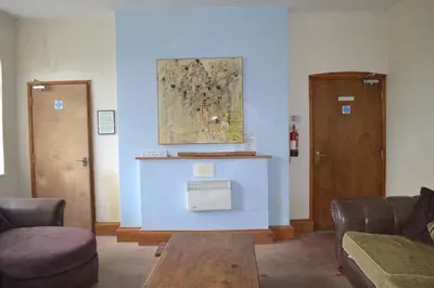 a living room with two chairs and a table at Llanfyllin Workhouse - Y Dolydd in Llanfyllin