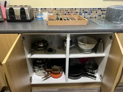 a kitchen cabinet filled with pots and pans at Llanfyllin Workhouse - Y Dolydd in Llanfyllin