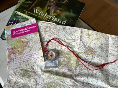 a map with a watch and two books on it at Trillow House, Clungunford, Ludlow in Clungunford