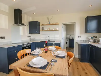 a kitchen with a wooden table and blue cabinets at Bethania in Oswestry