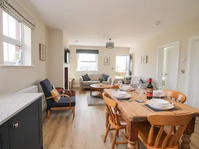 a kitchen and living room with a table and chairs at Bethania in Oswestry