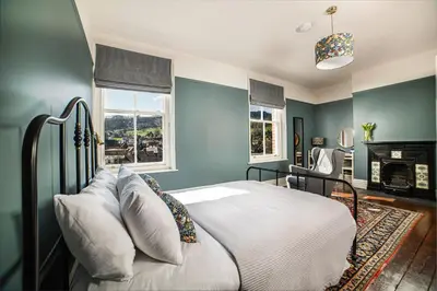 a bedroom with blue walls and a bed with pillows at Riversdale House Bed & Breakfast in Llangollen
