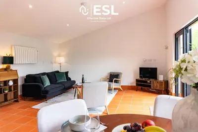 a living room with a couch and a table at Quarry View Garden Studio in Shrewsbury with Parking in Shrewsbury