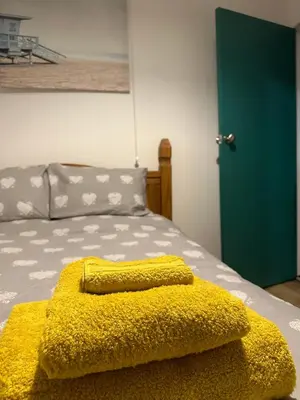 a yellow blanket sitting on top of a bed at Trawsfynydd Stone Cottage in Trawsfynydd
