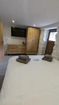 a bedroom with a large bed with two pillows on it at Grade II Lodge House 2 Bedroom in Trawsfynydd