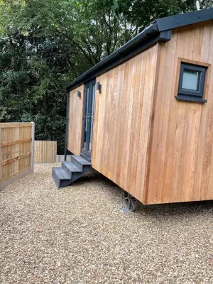 a wooden shed with a door and a staircase at Dee Lodge with private hot tub in Llangollen