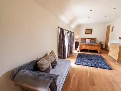 a living room with a couch and a bedroom at The Orchard in Knighton