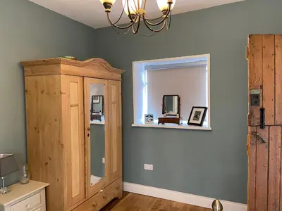 a room with a mirror and a wooden cabinet at The Little Coach House in Wales in Newtown