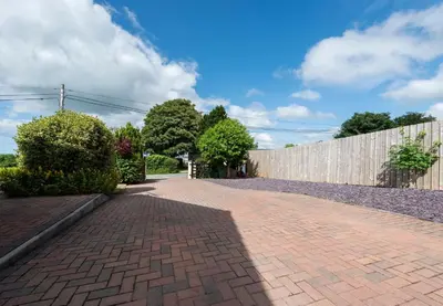 a brick driveway in front of a fence at Y Villa Môr in Llanarth