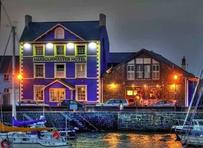 a purple building with boats in front of a marina at Y Villa Môr in Llanarth