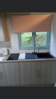 a kitchen with a sink and a window at Shepherds hut Lowri in Dolgellau