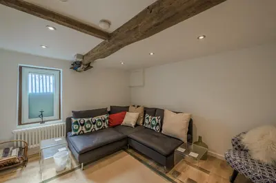 a living room with a leather couch and a window at St. John’s hill - with parking in Shrewsbury