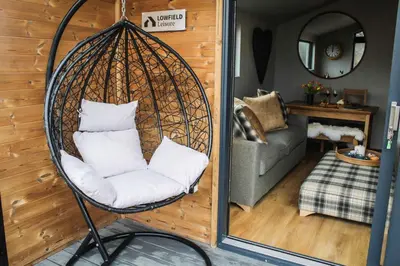 a swing chair with pillows in a living room at Fawns Rest in Nantmel