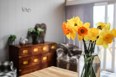 a vase filled with yellow and orange flowers on a table at Buck Barn in Nantmel