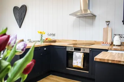 a kitchen with navy blue cabinets and a stove at Buck Barn in Nantmel