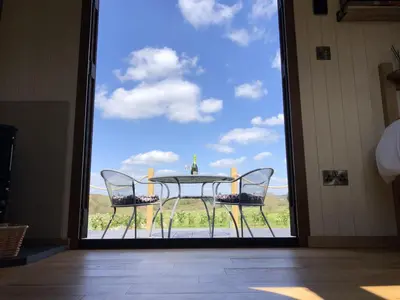 a glass door leading to a patio with a table and chairs at Mayflower in Rhayader
