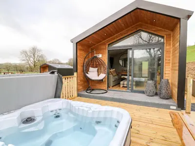 a hot tub on the deck of a house at Fawns Rest in Rhayader