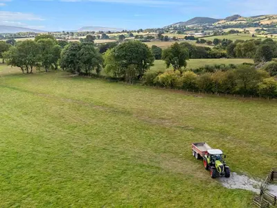 a tractor is driving through a field at Tin Shed in Rhayader
