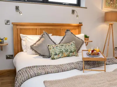 a bedroom with a bed with pillows and a table at Tin Shed in Rhayader