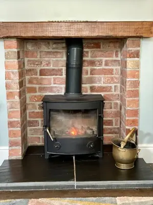 a black stove in a brick fireplace with a bucket at Hurdley House-Georgian Town House in Montgomery
