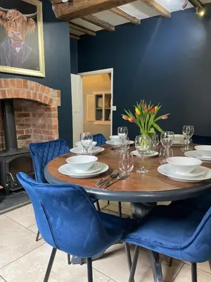 a dining room with a wooden table and blue chairs at Hurdley House-Georgian Town House in Montgomery