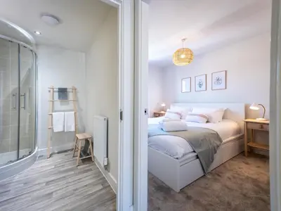 a white bedroom with a bed and a glass door at Brand new 1 bedroom modern contemporary apartment - Pass the Keys in Ludlow
