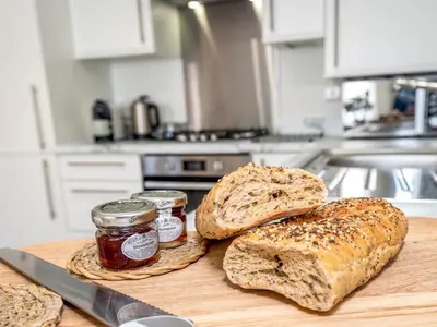 two loaves of bread and two jars of jam on a cutting board at Brand new 1 bedroom modern contemporary apartment - Pass the Keys in Ludlow