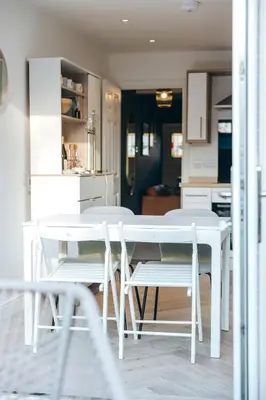a white dining table and chairs in a kitchen at Quaint Georgian house with Parking & Huge Garden 10 mins walk from town in Shrewsbury