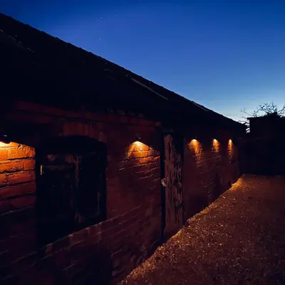 a brick wall with lights on it at night at Quaint Georgian house with Parking & Huge Garden 10 mins walk from town in Shrewsbury