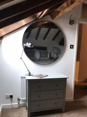 a mirror on top of a dresser in a room at Hay On Wye Welsh Townhouse in Hay centre in Hay-on-Wye