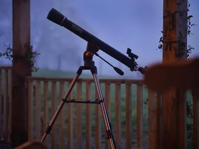 a telescope on a tripod next to a fence at Romantic country cabin with log burner, spectacular views, spa hot tub - Brecon Beacons National Park dog friendly in Llangadog