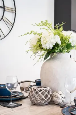 a table with a vase with white flowers on it at The Old Glassworks by Bevolve in Shrewsbury
