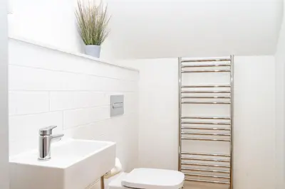 a white bathroom with a sink and a toilet at The Old Glassworks by Bevolve in Shrewsbury